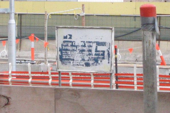 Faded Melbourne Docklands authority branded 'Little Collins Street Subway Extension' sign opposite platform 14