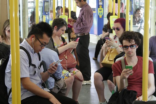 Tram full of passengers absorbed in their smartphones