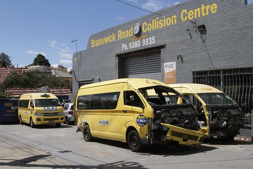 Smashed up Maxi Taxis outside a collision repair workshop in Brunswick