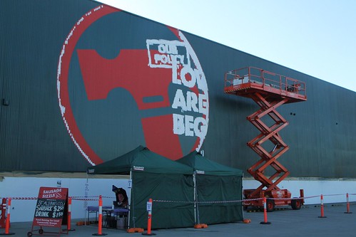 Painting over the 'Lowest prices are just the beginning' slogan on the side of a Bunnings Warehouse store