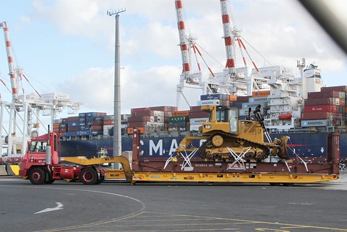 Terminal tractor hauls a Mafi roro trailer, Caterpillar D6T bulldozer loaded onto a 40 foot ISO flat rack