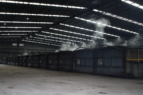 Steam rises from the loaded composting cells inside the main shed