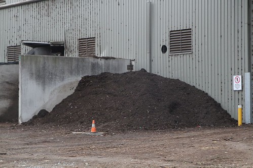 Stockpiles of finished compost outside the composting shed