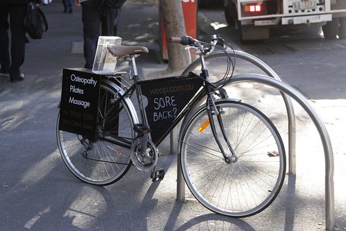 Bike covered with advertising, chained to a bike rack