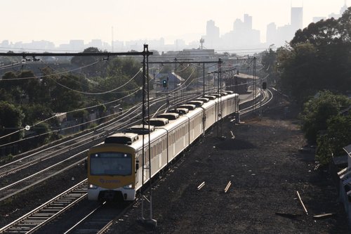 Siemens train departs Middle Footscray under a hazy sky