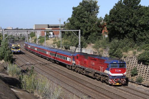 N464 leads a down Geelong train into Footscray, a spark close behind on the parallel track