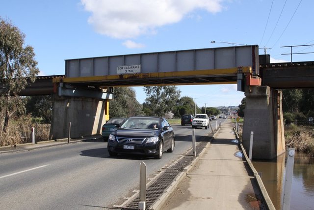 Southbound road traffic passes under the bridge