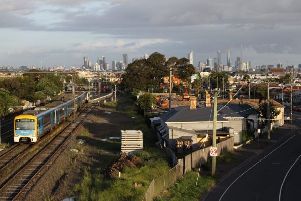 Siemens train approaches Middle Footscray, passing the remains of houses compulsorily acquired for the RRL project