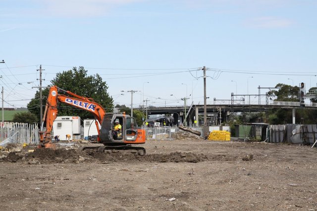 Excavator digging up the now cleared site