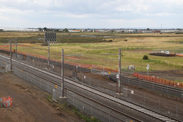 Looking down the line, LX over the standard gauge to access the site. Note the new stanchion bases in the dirt, the down line will be slewed for an island platform