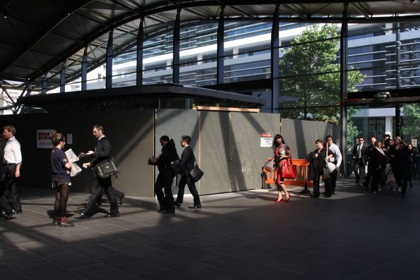 Docklands workers dodge the new shops at the upper level Collins Street entrance