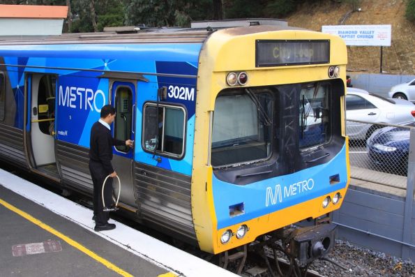 Comeng 302M on arrival at Greensborough on the up, the signaller collects the train staff from the driver