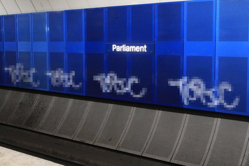 Tags spray painted along the walls at Parliament station