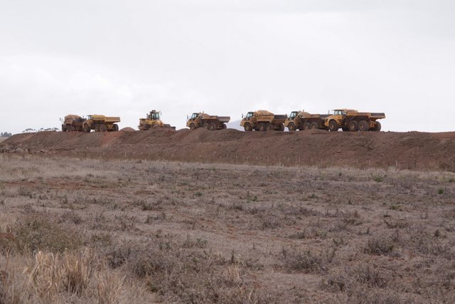 Heavy duty dump trucks lined up on the RRL track embankment