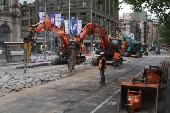 Six excavators breaking up concrete at the corner of Bourke and Elizabeth Streets