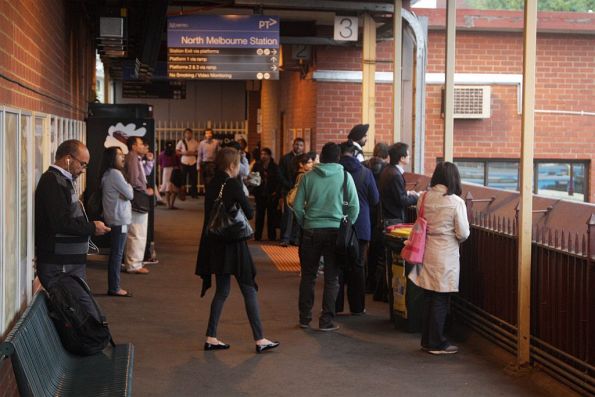 With the platform for the next City Loop train from North Melbourne unknown, passengers wait on the overhead concourse