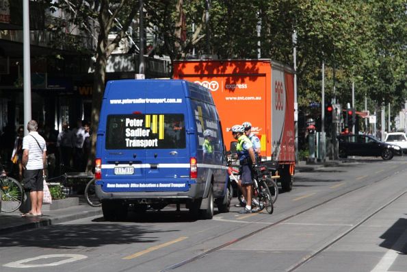 Victoria Police officers on bike patrol talk to the van that drove through a Swanston Street tram stop