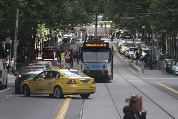 Taxi driver on Collins Street undeterred by the new plastic kerbs along the tracks