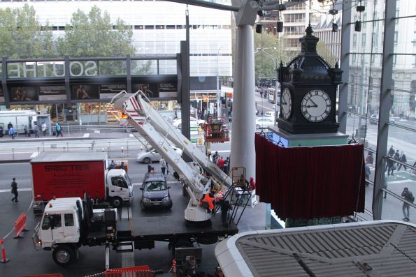 Stage rigging company setting up a big red curtain over the recently installed Water Tower Clock