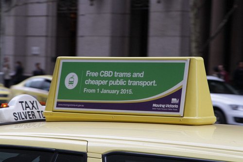 'Free CBD trams and cheaper public transport' propaganda atop a Melbourne taxi