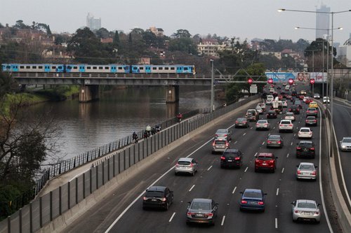 Siemens train crosses the Cremorne railway bridge, with peak hour traffic grinding along the Monash Freeway