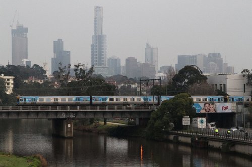 Alstom Comeng crosses the Cremorne railway bridge over the Yarra, with the CBD skyline behind