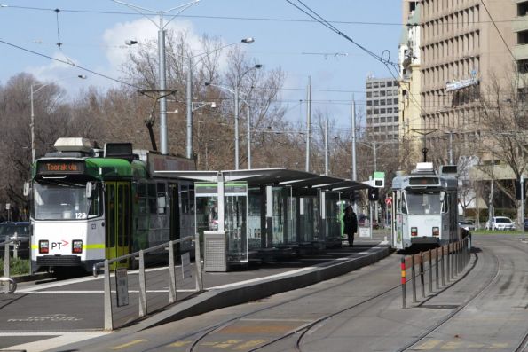 Z3.123 stops in the side platform at Domain Interchange with a southbound route 8 service, as a classmate continues down St Kilda Road