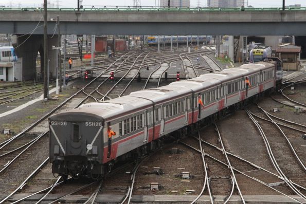 Three shunters wave to the driver as carriage set SSH26 is moved across to the platforms at Southern Cross