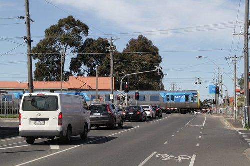 Down Upfield train crosses the Gaffney Street level crossing at Batman station