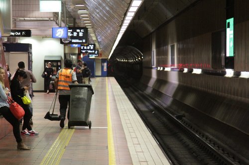 Cleaner does the rounds of Melbourne Central looking for litter, since rubbish bins are no longer provided