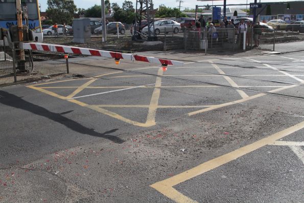 Shattered bits of orange, red and clear plastic mark multiple crashes at the Bell Street level crossing in Coburg