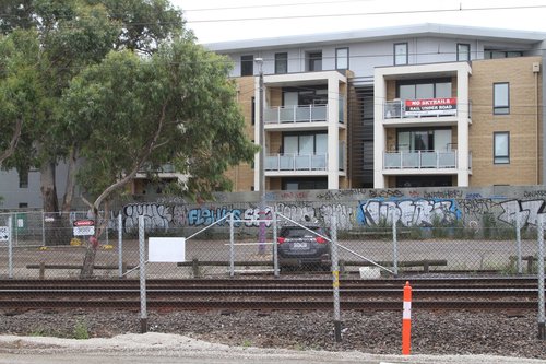 'No Skyrails - Rail Under Road' banner tied to the balcony of a third story apartment at Hughesdale