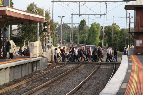 Level crossing clear, as a stream of pedestrians cross the railway at Yarraville