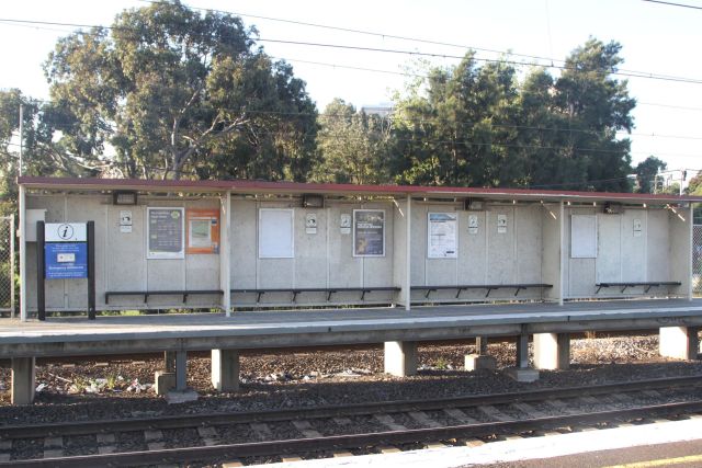 Four concrete bus stop shelters pass for the citybound waiting area at South Kensington platform 1