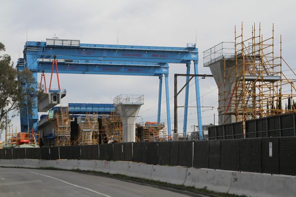 Pair of portal cranes at work moving a completed bridge span at Murrumbeena station