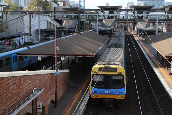 Pair of City Loop bound services at North Melbourne, the train on platform 1 having the signal to proceed