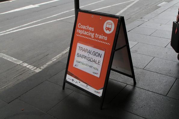 'Traralgon & Bairnsdale coaches departure here' sign outside Flinders Street Station