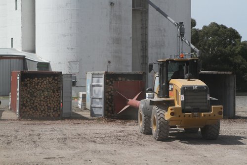 Specially fitted loader pushes the logs into a 40 footer container