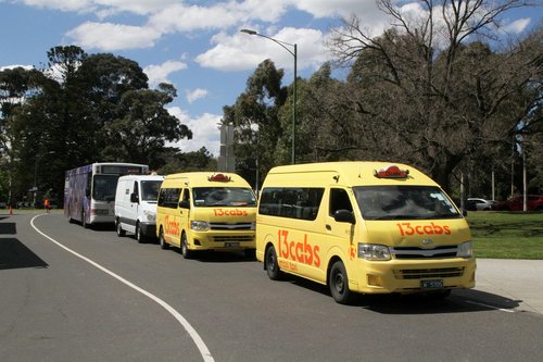 Pair of wheelchair accessible taxis waiting with a Ventura service van and standby bus off St Kilda Road