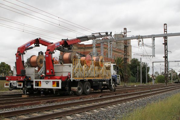 Hi-rail trucks at work installing the new double wire traction power feeders at Albion