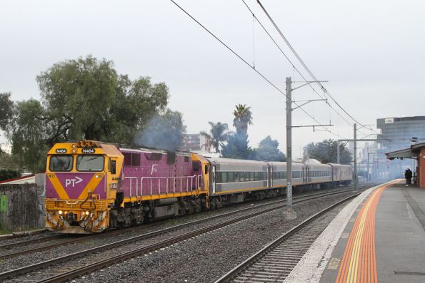 N464 leads stripped standard gauge carriages and power van PCJ493 through Middle Footscray