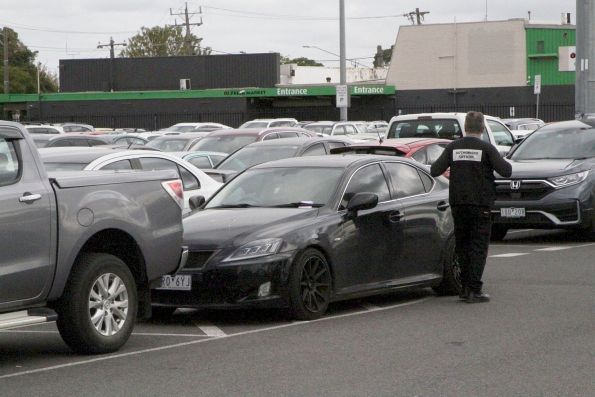 Authorised Officers ticketing cars illegally parked in a railway station car park