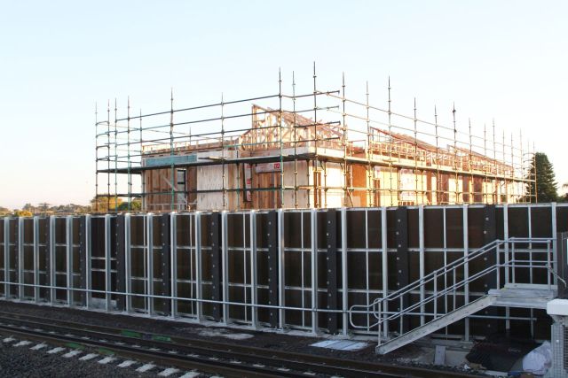 Three storey townhouse development peeks over the noise walls on the new elevated track