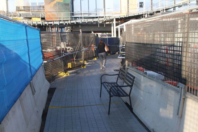 Marquee brand 'Steel Park Benches' from Bunnings beside the walkway through the construction site to platform 1