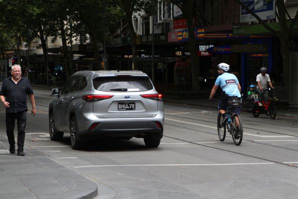 Victoria Police offices on bikes talk to a confused motorist who tried to drive down Swanston Street