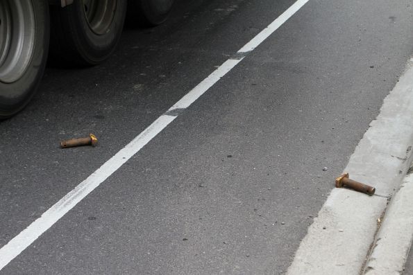 Twistlocks on the ground after a 40 foot container was dislodged from the truck after it hit the Napier Street railway bridge