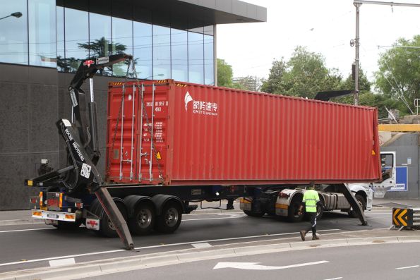 Sidelifter truck picks up the damaged 40 foot container