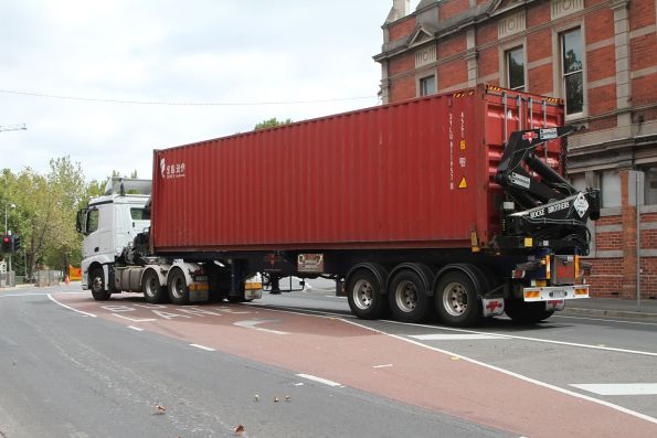 Sidelifter truck takes the damaged 40 foot container away